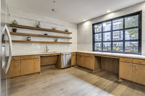 Dallas apartment for rent - A kitchen with wooden cabinets and a large window.