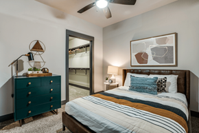 Dallas apartment for rent - A bedroom with a bed, nightstand, and a dresser with a mirror.