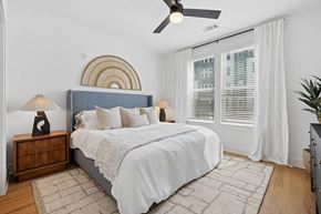 Charlotte apartment for rent - A bedroom with a bed, nightstand, and a ceiling fan.