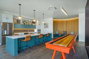 Seattle apartment for rent - a game room with a shuffleboard table and a kitchen