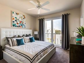 Boca Raton apartment for rent - A bedroom with a large bed and a painting on the wall.