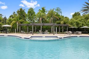 Orlando apartment for rent - A pool with a deck and umbrellas.