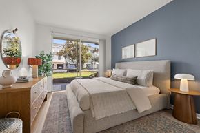 Orlando apartment for rent - A bedroom with a bed, nightstand, and a chair.