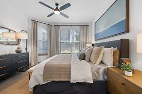 Atlanta apartment for rent - A bedroom with a large bed, a ceiling fan, and a painting on the wall.