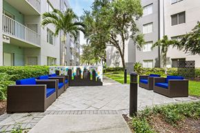 Tampa apartment for rent - A patio area with blue cushioned seating and a mural of a cityscape.