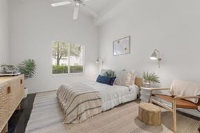 Tampa apartment for rent - A bedroom with a bed, a chair, and a plant.
