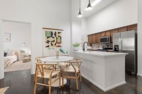 Tampa apartment for rent - A kitchen with a white island and wooden chairs.