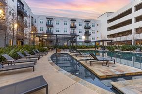 Richardson apartment for rent - an outdoor pool with chaise lounge chairs and a building in the background