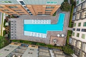 Atlanta apartment for rent - A swimming pool is surrounded by a brick wall and a glass ceiling.