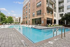 Atlanta apartment for rent - A swimming pool in front of a brick building.