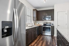 Atlanta apartment for rent - A modern kitchen with a stainless steel refrigerator and wooden floors.