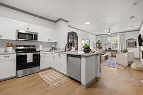 Denver apartment for rent - A modern kitchen with white cabinets and a wooden floor.