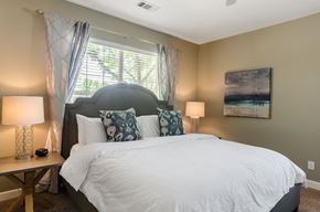Superior apartment for rent - A bedroom with a large bed and a painting on the wall.