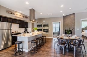 Superior apartment for rent - A modern kitchen with a large island and a dining table set for four.