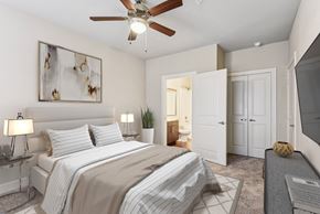 Austin apartment for rent - a bedroom with a large bed and a ceiling fan