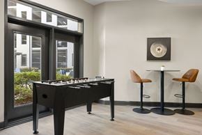 Sandy Springs apartment for rent - A black pool table with a white cloth and a light brown leather chair.