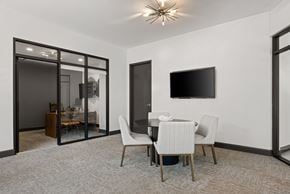 Sandy Springs apartment for rent - A modern dining room with a glass door and a flat screen TV on the wall.