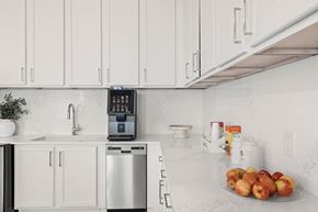 Miami apartment for rent - A kitchen with a stainless steel dishwasher and a digital clock on the wall.