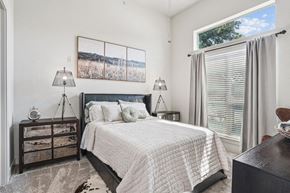 Dallas apartment for rent - a bedroom with a bed and a large window