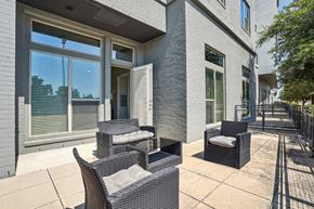 Dallas apartment for rent - a patio with chairs and a table in front of a building