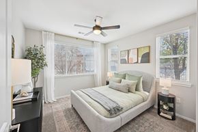 Lafayette apartment for rent - A bedroom with a bed, nightstand, and a ceiling fan.