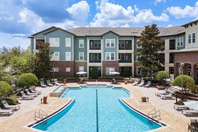 Sanford apartment for rent - A large swimming pool in front of a multi-story apartment building.