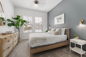Sanford apartment for rent - A bedroom with a bed, nightstand, and a plant.