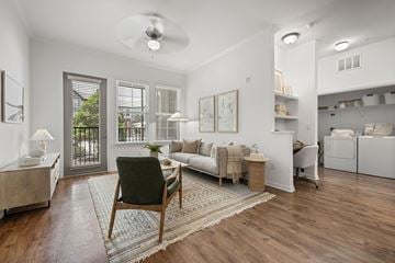 Sanford apartment for rent - A living room with a green chair and a rug in the middle.