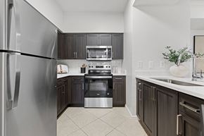 Miramar apartment for rent - A modern kitchen with dark wood cabinets and stainless steel appliances.