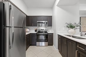 Miramar apartment for rent - A modern kitchen with a stainless steel refrigerator and dark brown cabinets.