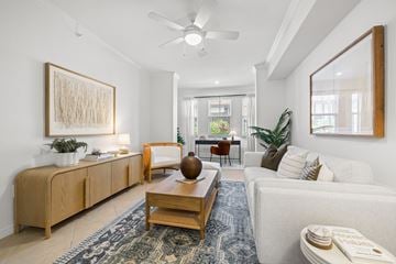 Miramar apartment for rent - A living room with a white couch, a wooden coffee table, and a large painting on the wall.