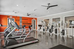 Murrieta apartment for rent - A gym with orange walls and a treadmill in the foreground.