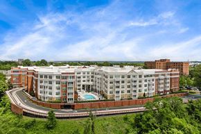 Alexandria apartment for rent - A large multi-story building with a pool in the middle of a green landscape.