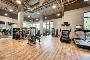 Redmond apartment for rent - a gym with cardio machines and weights on a wooden floor