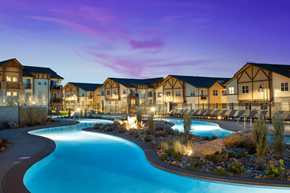 Parker apartment for rent - A swimming pool in front of a building with a sunset in the background.