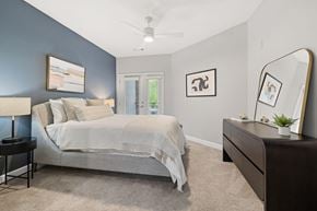 Atlanta apartment for rent - A bedroom with a bed, nightstand, and a ceiling fan.
