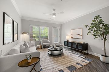 Atlanta apartment for rent - A living room with a grey couch, a coffee table, a side table, a plant, and a painting on the wall.