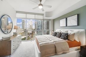 Charlotte apartment for rent - A bedroom with a large bed and a view of the city.