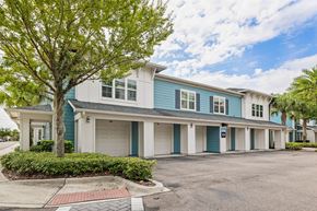 Tampa apartment for rent - A tree in front of a blue and white house.