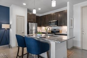 Austin apartment for rent - A kitchen with a blue chair and a granite counter.
