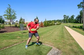 Raleigh apartment for rent - a man holding a frisbee on a grass field