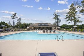 Wilmington apartment for rent - a swimming pool with chairs and a building in the background
