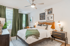 Alpharetta apartment for rent - A bedroom with a bed, nightstand, and a ceiling fan.