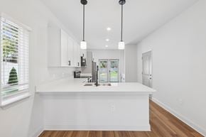 Knightdale townhouse for rent - A kitchen with white cabinets and a white island.