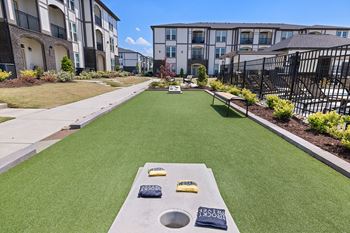 Outdoor gaming area with bocce ball, cornhole, and foosball