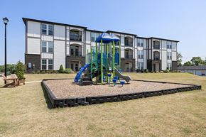 Monroe apartment for rent - A playground with a blue slide in front of a building.