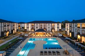 Monroe apartment for rent - A large building with a pool in front of it.