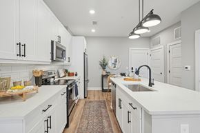 Charlotte apartment for rent - A modern kitchen with white cabinets and a central island.