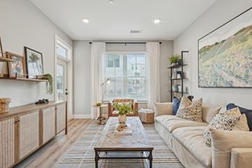 Charlotte apartment for rent - A living room with a large couch, a coffee table, and a painting on the wall.