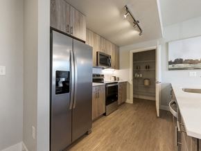 Longmont apartment for rent - A modern kitchen with a stainless steel refrigerator and wooden cabinets.
